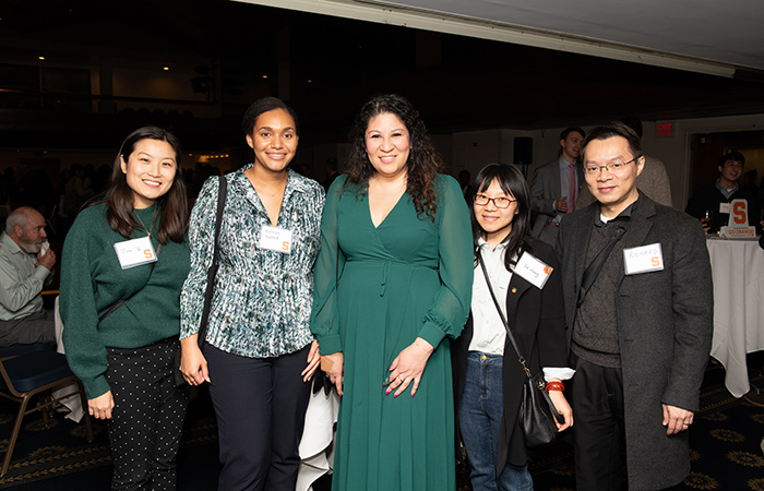 A group of alumni and guests gather for a photo